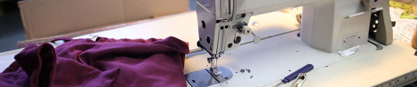 Sewing machine with maroon fabric.