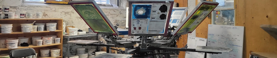 Proper Designworks Screen printing machine with blue and green screens.