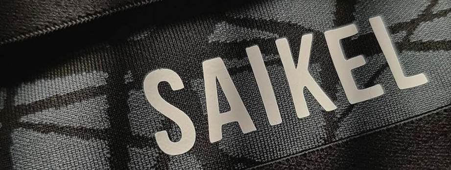 White Saikel graphic printed on black and grey patterned fabric.